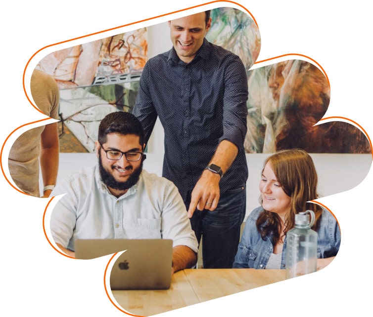 Foto de uma equipe trabalhando sorridente em frente ao laptop.